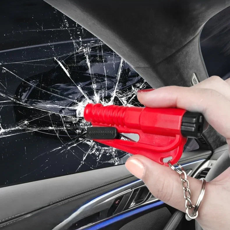 Hand using red emergency car window breaker to shatter vehicle glass, Voltaxa safety tool